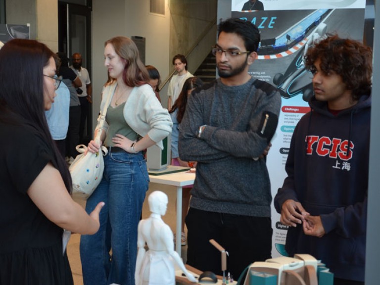 Graduate talking to two event guests in front of their table