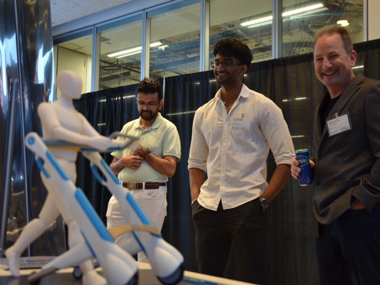 Three people smiling looking at project table