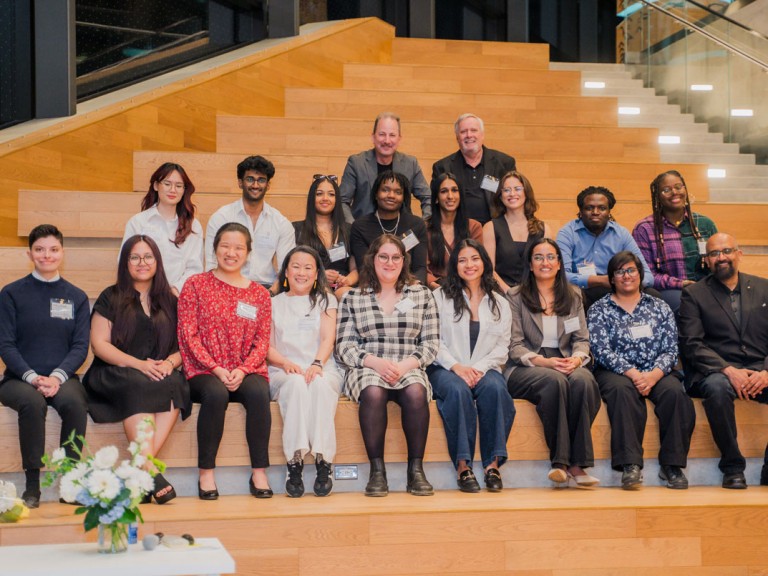 Group of people sitting on steps posing for photo