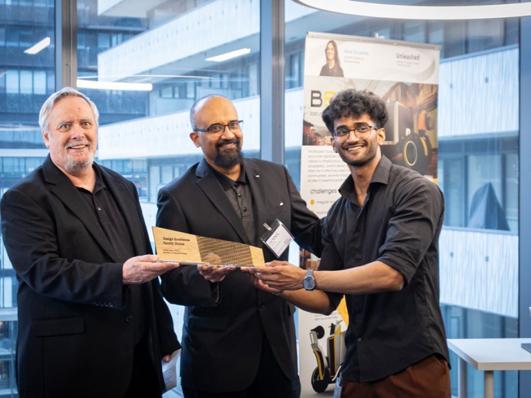 Industrial design graduate award winner and two others holding award and posing for camera