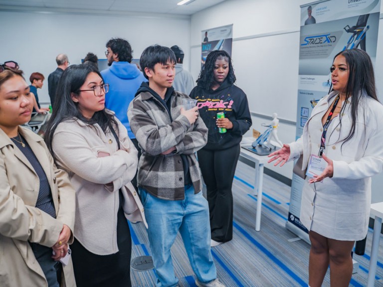 Industrial design graduate in discussion with four event guests