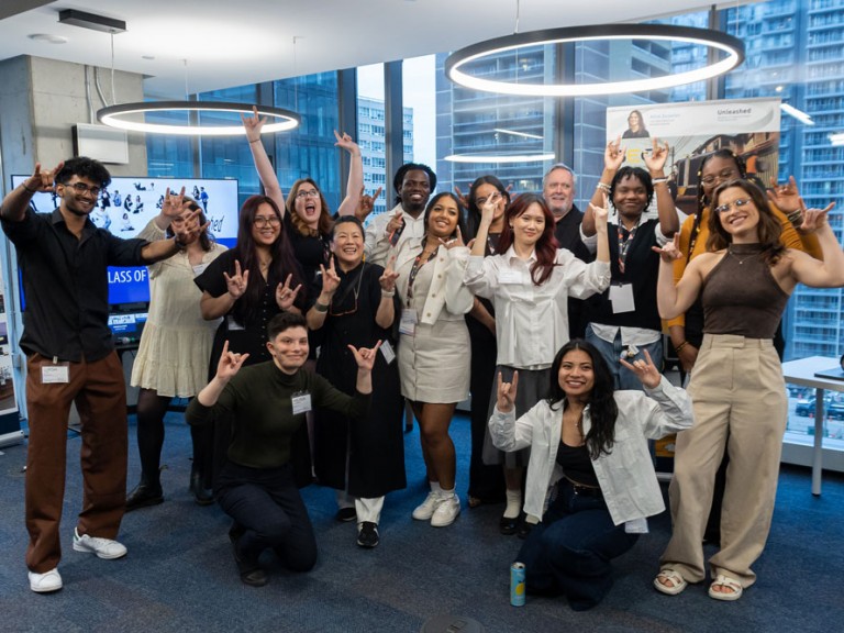 Group of people raising hands excitedly for photo