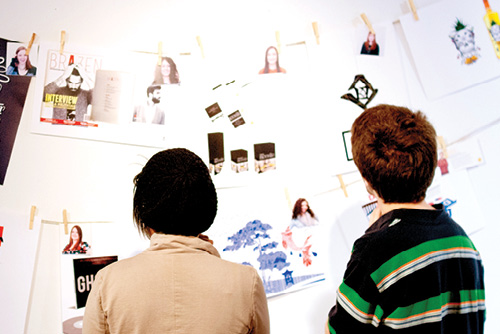 People looking at designs on wall